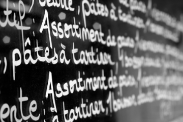 Menu written on a glass window outside a cafe